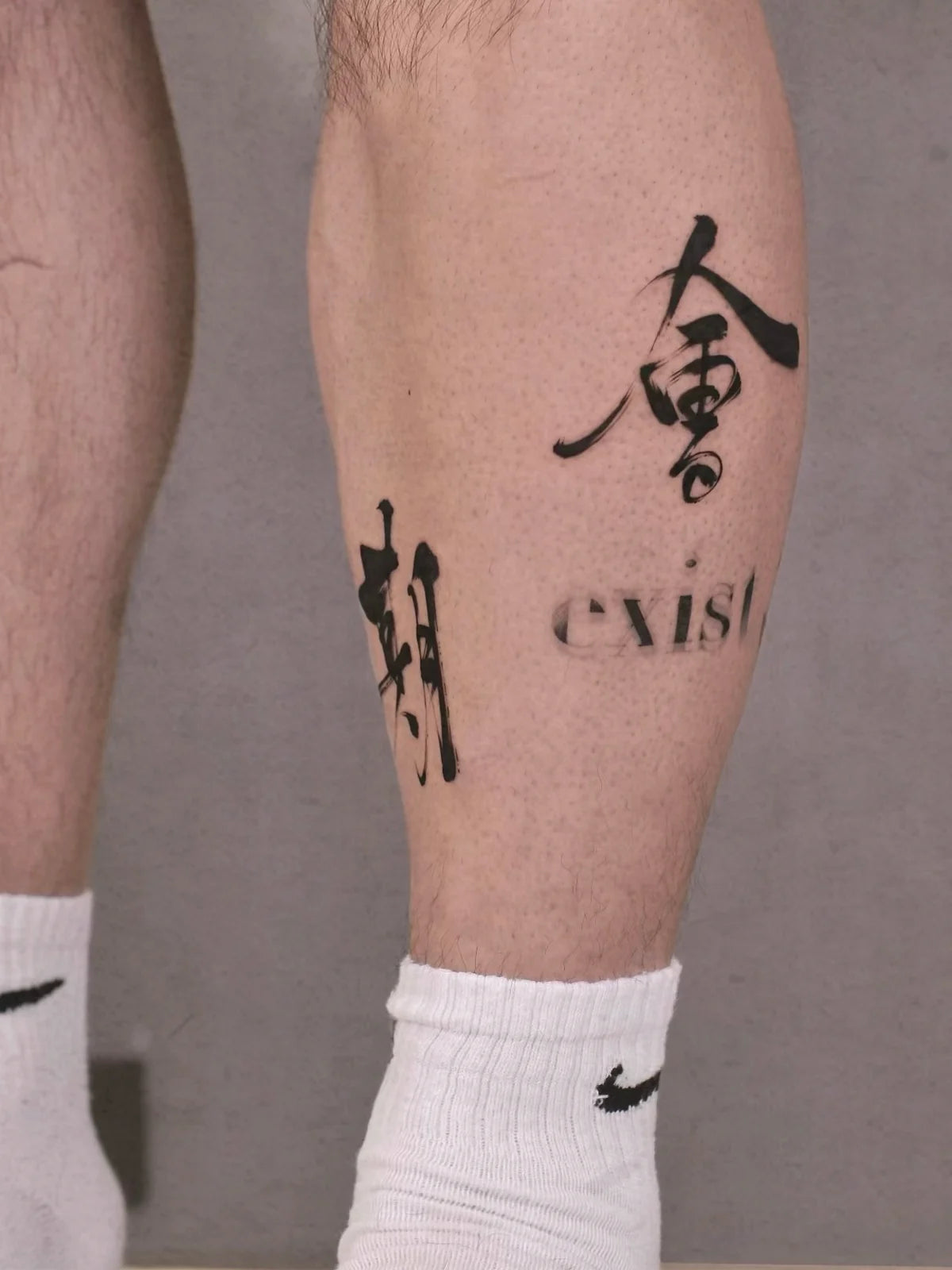 Black Chinese character tattoos on the calves